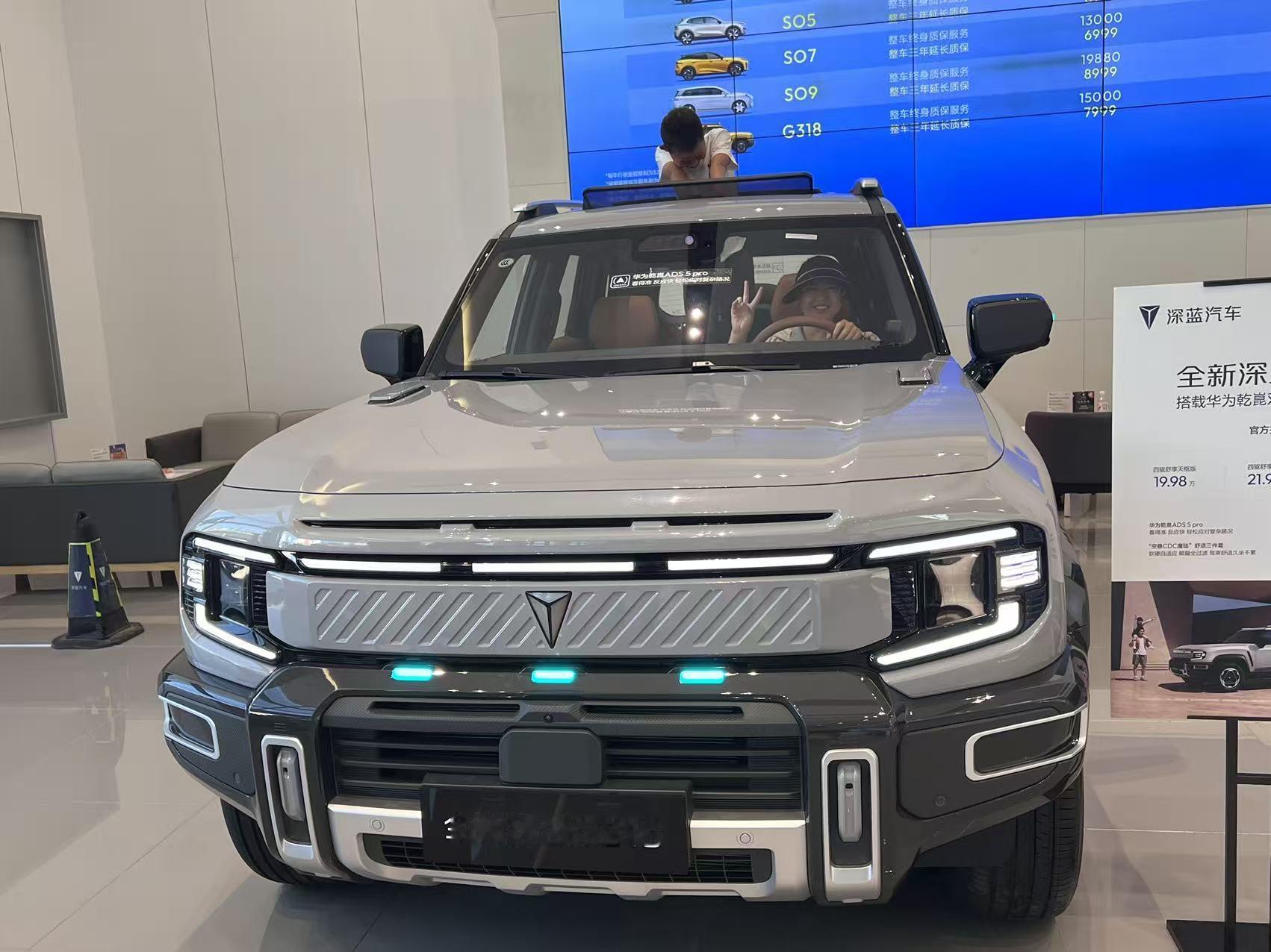 深蓝G318实车这方盒子造型开出去确实吸睛，展厅里银灰色车身配上外挂备胎，硬派范儿拉满。坐进车内，棕褐色皮质内饰一搭大尺寸连屏，豪华感和科技感都到位了。华为鸿蒙座舱上车机流畅度没得说，电子换挡机构精致顺手。最点睛的是那个小蓝灯，车头一亮相辨识度直接拉满，既有个性又有科技味。
 全新深蓝G318试驾