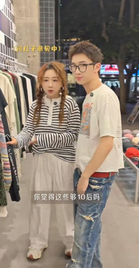 傅首尔最近和17岁的儿子多乐逛街，视频一出，很多人第一反应是：这是当年《奇葩说》段子里那个小男孩？
对，就是他。现在快180cm了，比妈妈高出一头。戴眼镜，穿街头风，清秀得像傅首尔的“少年版”。逛街全程牵着妈妈的手，还主动帮她挑衣服，带她试“10后街头风”。母子俩互怼互侃，像姐弟。
最让人感慨的不是
