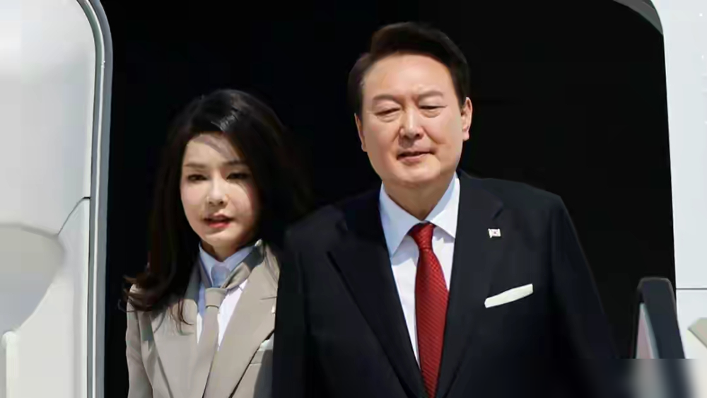 金建希下了专机，身旁的尹锡悦像她的随行人员。
两天六套造型，从灰色学院风领带到藕粉套裙，再到绿色高腰半裙。她把出访穿成了个人秀场，每一套都精确到围巾与风衣的颜色闭环。媒体夸她行走的穿衣模板，镜头盯着她的腰线、发型、冻龄脸。
唯独没人问一句：这些衣服是谁选的，又是穿给谁看的。
一个第一夫人，把外