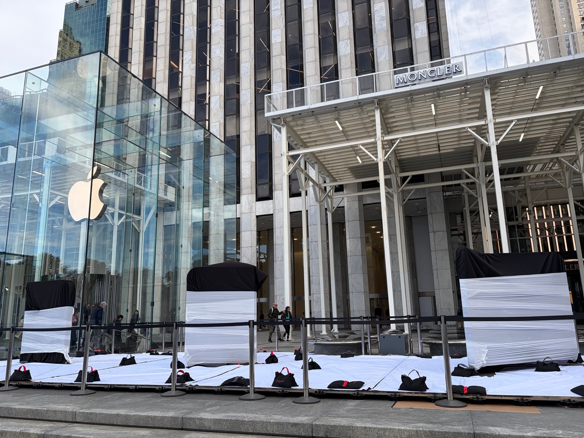 【纽约第五大道 Apple Store 零售店现身巨型 iPhone Duo 装置】

在 iPhone Duo 于 10 月 23 日（星期五）正式发售之前，Apple 正在纽约第五大道的 Apple Store 零售店外准备巨型 iPhone Duo 装置。

根据 LChenlz 用户发布的照片​​显示了玻璃立方体旁广场的这些装置。它们的具体设计被包裹和黑色罩 ​