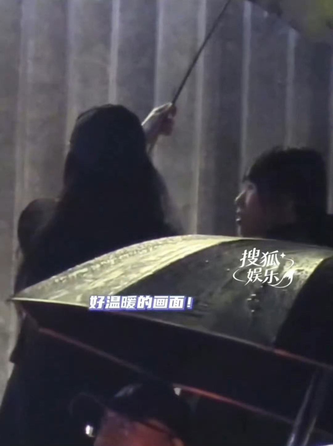 夜色沉下来，火锅店门外猝然泼下一场大雨。

黑色的车稳稳停在檐下，助理先一步下车，撑开那把印花雨伞，绕到后座开门。

刘亦菲弯腰踏出车门，雨丝呼啸着砸落地面。雨伞大半都偏向她这边，举伞的小姑娘半边肩膀直接露在雨里，很快就被雨水打湿。

她一眼便看见了。

没有出声，只是马上抬手，稳稳握住 ​