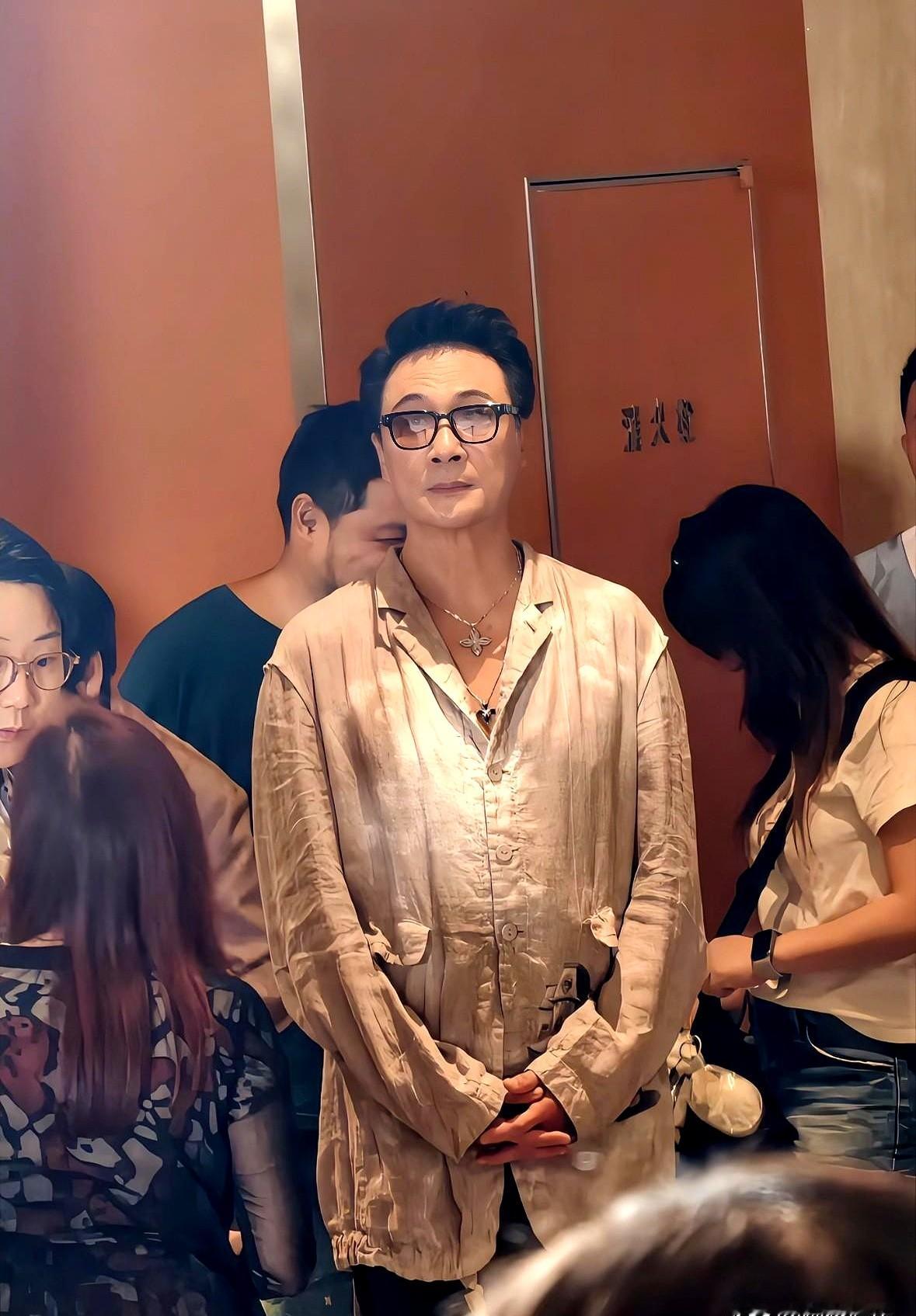 64岁的吴镇宇顶着乱发走出来时，现场的镜头差点没对上焦。

没有打光板，撤掉十级滤镜，这位曾经在银幕上拿枪指着别人脑袋的狠角色，如今脸颊肉眼可见地往下搭。眼角的褶子夹着疲态，西装底下的腰身也悄悄鼓起了一圈。

过去大家总拿他跟那些吃了防腐剂的同行比。但镜头一关，谁也拦不住时间。他没去拉皮，没打玻尿酸