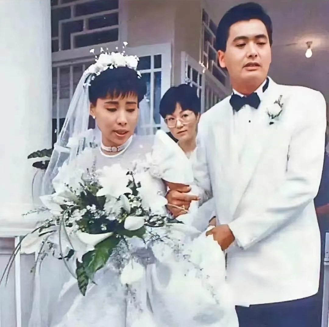 明确微头条重写要求
1987年的新加坡，一场万众瞩目的婚礼正在举行。32岁的周润发身着一袭白色西装，搭配黑色领结，风度翩翩；身旁28岁的新娘陈荟莲身穿洁白婚纱，手捧花束，笑容温婉。这张照片捕捉的，正是二人携手走出婚礼礼堂的瞬间，郎才女貌，羡煞旁人。

那一年的周润发，正处在演艺事业的巅峰。《上海滩》