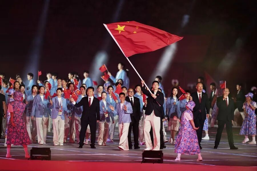 五星红旗迎风入场！名古屋亚运开幕式，中国代表团惊艳登场！
 
名古屋亚运会开幕式正式拉开帷幕，当中国体育代表团踏步走入赛场，鲜艳的五星红旗在灯光下熠熠生辉，瞬间抓住全场目光。这支远赴海外的队伍阵容庞大，既有久经沙场、大赛经验丰富的老将，也有大批初次登上亚运舞台的年轻健儿。两名旗手并肩向前，男篮选手胡