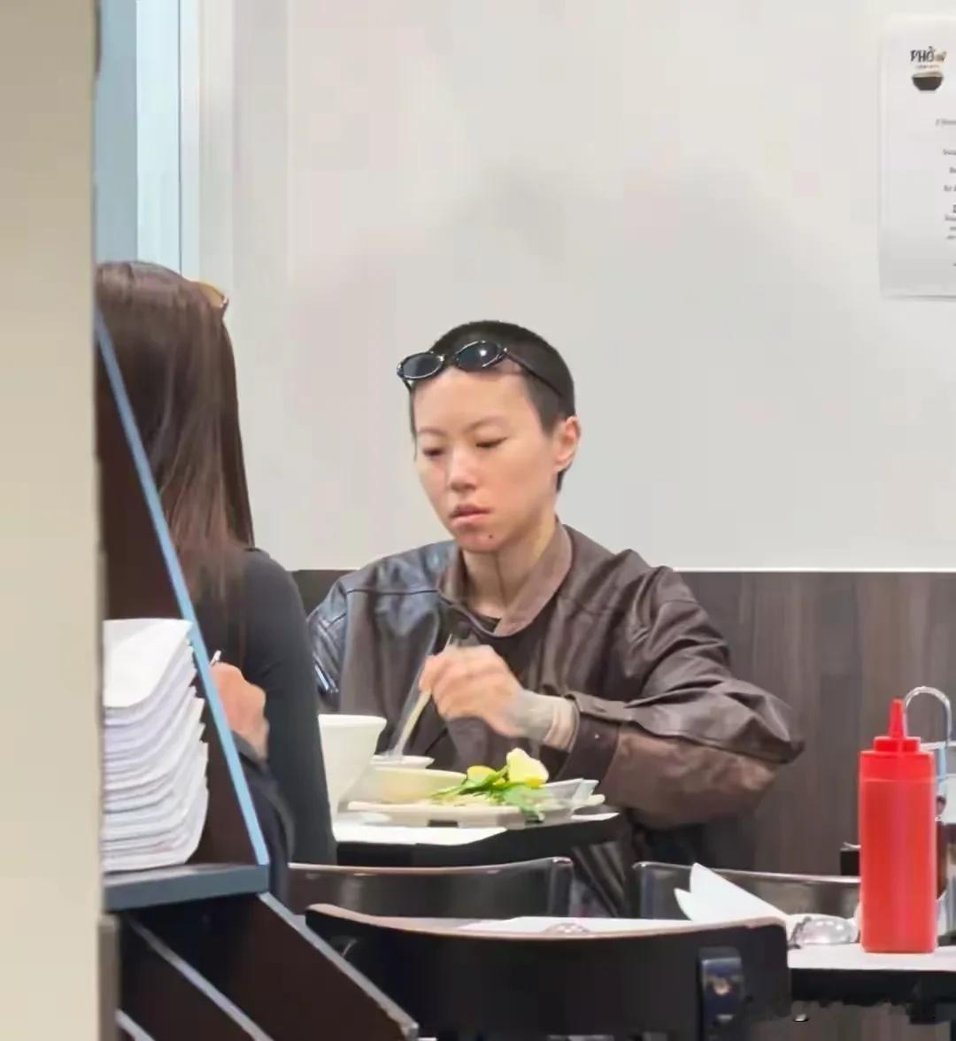 有网友在法国巴黎的一家餐馆偶遇29岁的窦靖童，当时她正在店里吃汤面。她留着寸头短发，下巴处能看到纹身，一身偏中性的穿搭，看起来又酷又洒脱。
单论长相，她的颜值属于普通类型，对比母亲王菲年轻时候的惊艳模样，还是有不小差距。