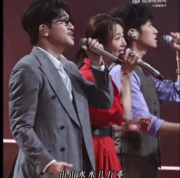 2026年湾区升明月晚会上，三位主演的同台合唱，瞬间戳中无数观众的怀旧情绪。
角色还原细节拉满
三人特意复刻了剧中经典造型：苏有朋贴上杜飞标志性的小胡子、架起圆框眼镜，古巨基手持何书桓常穿的西装外套，林心如一袭红衣亮相。全开麦的演唱搭配背景滚动的剧集老片段，台下观众几乎全程跟着旋律合唱。
两次缺席暗