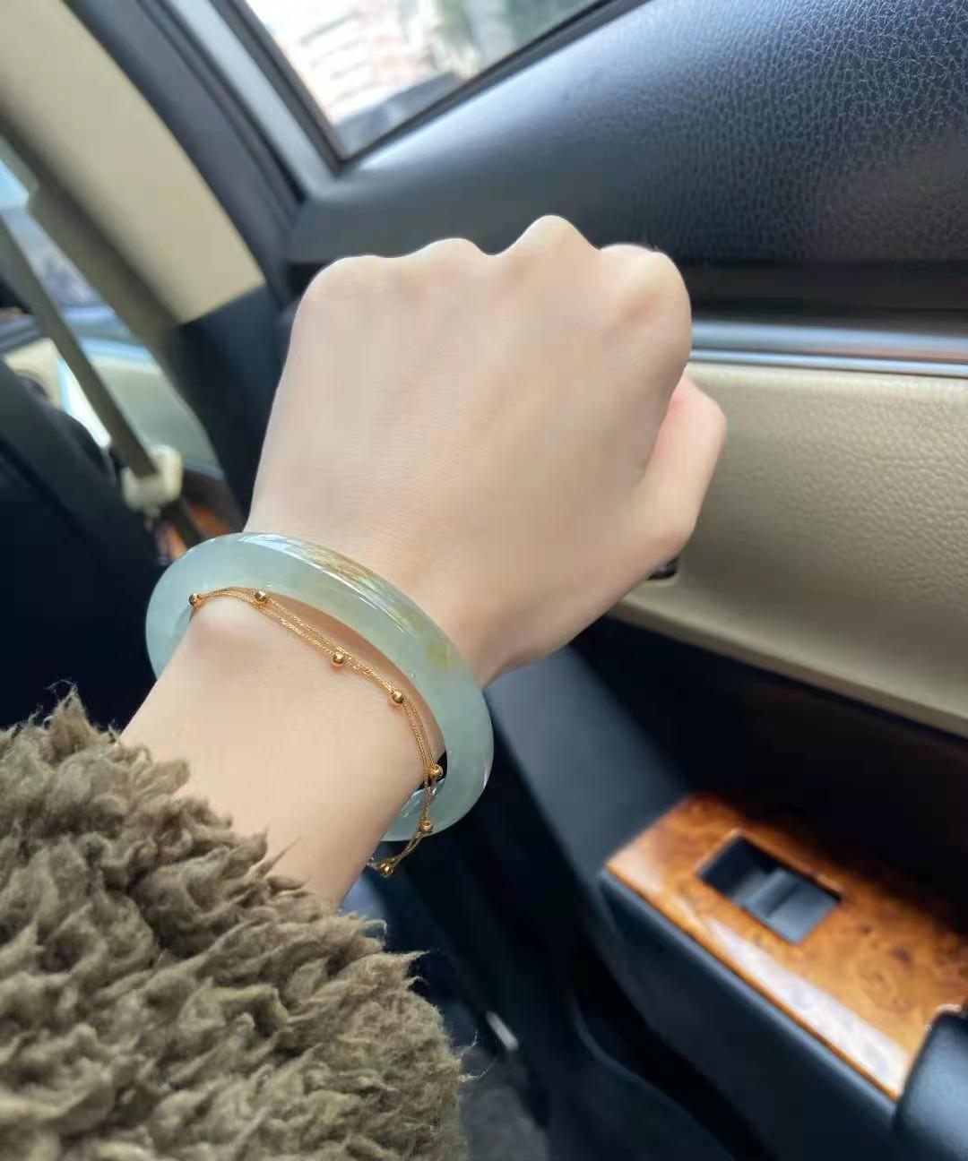 冰黄翡飘花翡翠手镯 浅钱的颜色上边飘了几丝黄翡，做成了细条的款式，显得...