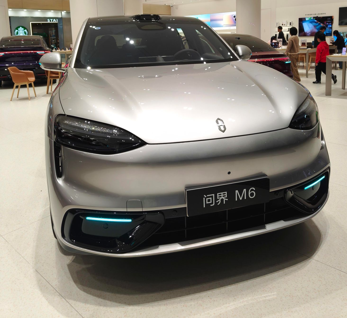 到店试驾问界 M6：城区道路体验，这台大五座的舒适取向藏在细节里
试驾车辆来自鸿蒙智行授权体验中心，路线以城区主干道为主，包含一段高架快速路。
站在车旁，问界 M6 的车身姿态比图片中更显体量，线条走年轻运动路线。拉开车门坐进前排，座椅填充物偏软，侧翼并不会把人夹得很紧，零重力姿态开启后，腿托与靠背