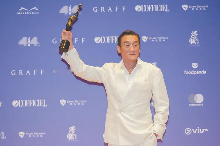 梁家辉26岁拿金像影帝，被封杀时去夜市摆地摊，娶江嘉年穿旧西装，如今五座奖杯还是牵她手爬山。
