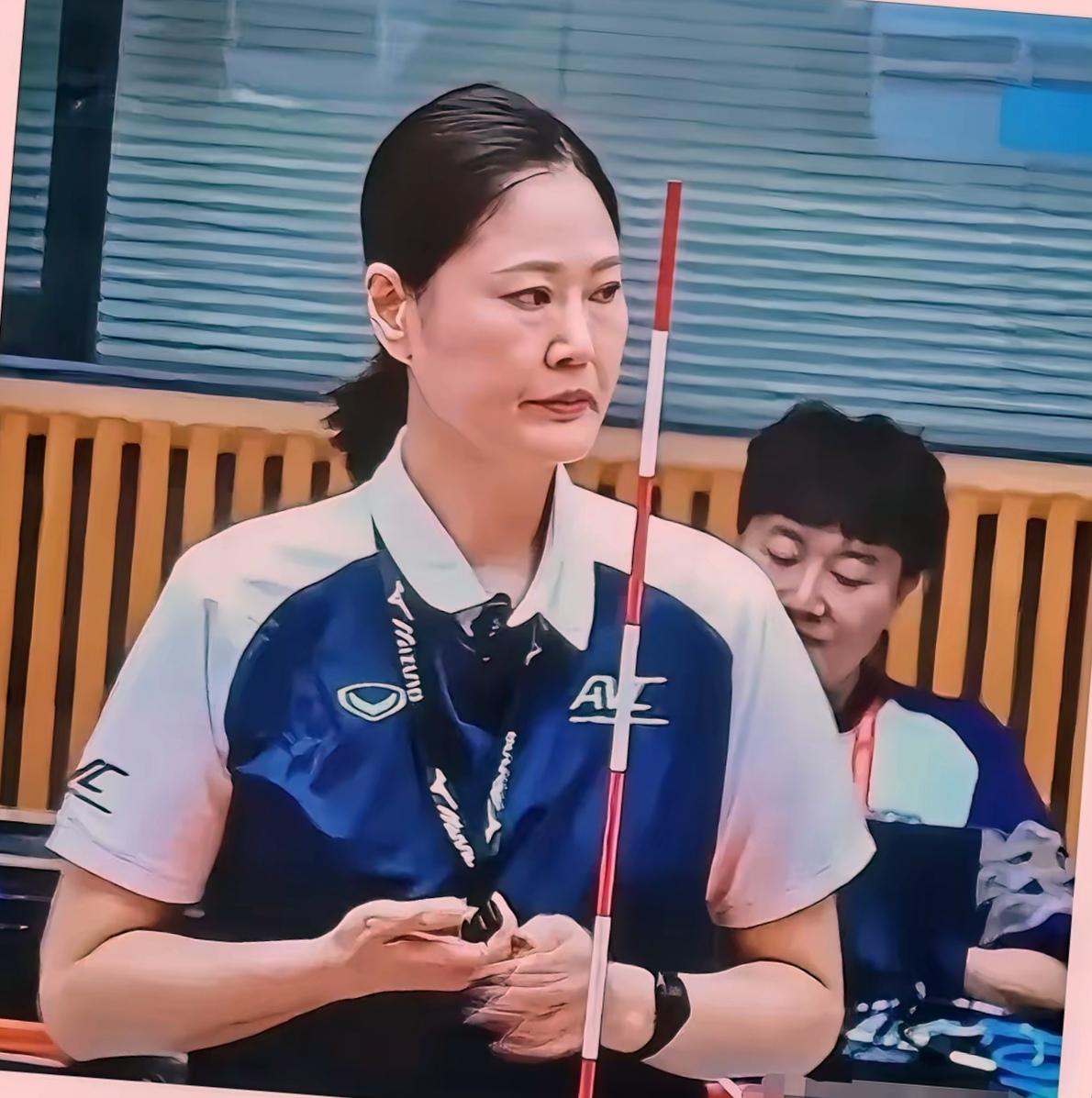 谁能想到，亚运女排决赛最出圈的不是扣球的队员，竟是网前那位手执法杖的女主裁？
比赛打得难解难分，转播镜头却一次次被她“抢走”。举手投足干净利落，着装一丝不苟，站在高椅旁边腰板笔直，眼神扫过场地时不怒自威。观众看得入神，弹幕里都在打听：这位裁判什么来头？
说起来，她并非无名之辈。常年执裁国内外大大小小