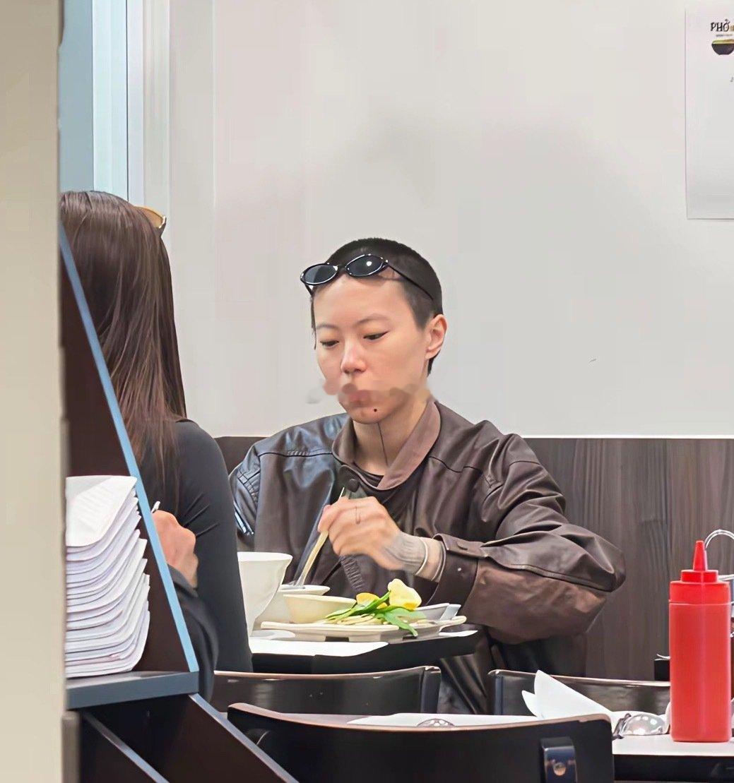 29岁窦靖童在法国巴黎一家餐馆吃汤面被偶遇，她留着寸头短发，下巴刺了纹身，中性打扮非常酷。 ​