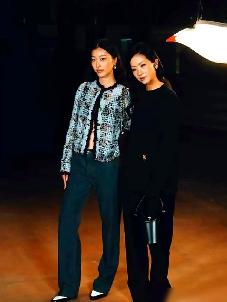 窦靖童跟陈奕迅闺女陈康堤，巴黎头排挨着坐，热搜炸了。
这俩孩子，从小被王菲陈奕迅抱着串门，如今一个穿黑皮衣戴墨镜，一个安安静静坐旁边。
有意思的是，陈康堤上个月发国语歌，歌词是窦靖童写的。
辛芷蕾也坐旁边，一身米白红边针织裙，生图直接刷屏。
王菲跟陈奕迅那代人的交情，没散，全传给孩子了。
