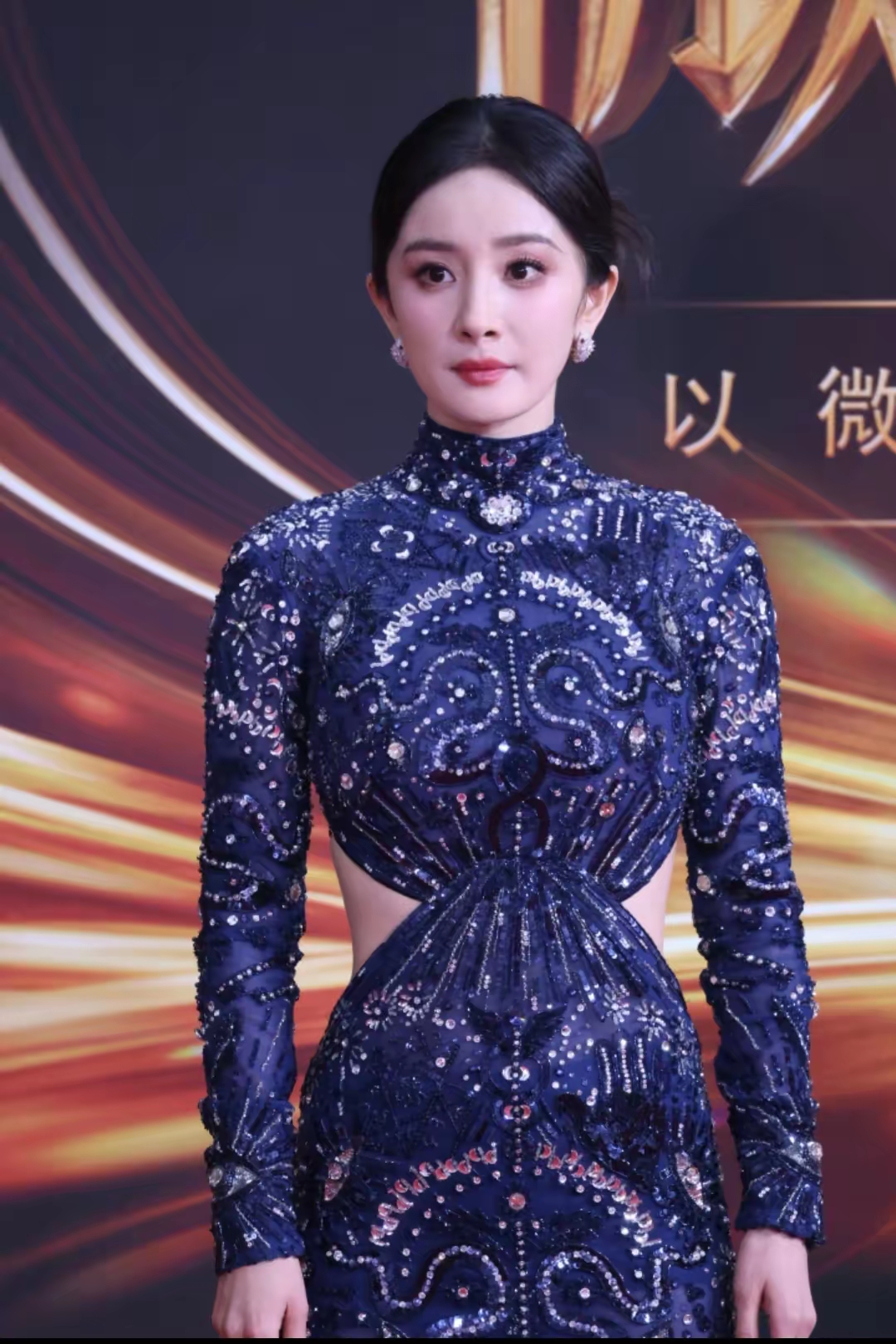 杨幂这身藏蓝色钉珠礼服太惊艳了！高领长袖设计自带端庄气场，精致的刺绣水钻布满整件裙身，华丽感拉满。腰间巧妙的镂空剪裁，恰到好处露出腰线，摆脱沉闷，妩媚又大气。整套造型华贵典雅，星光熠熠，妥妥的红毯女王风范，你们觉得好看吗？