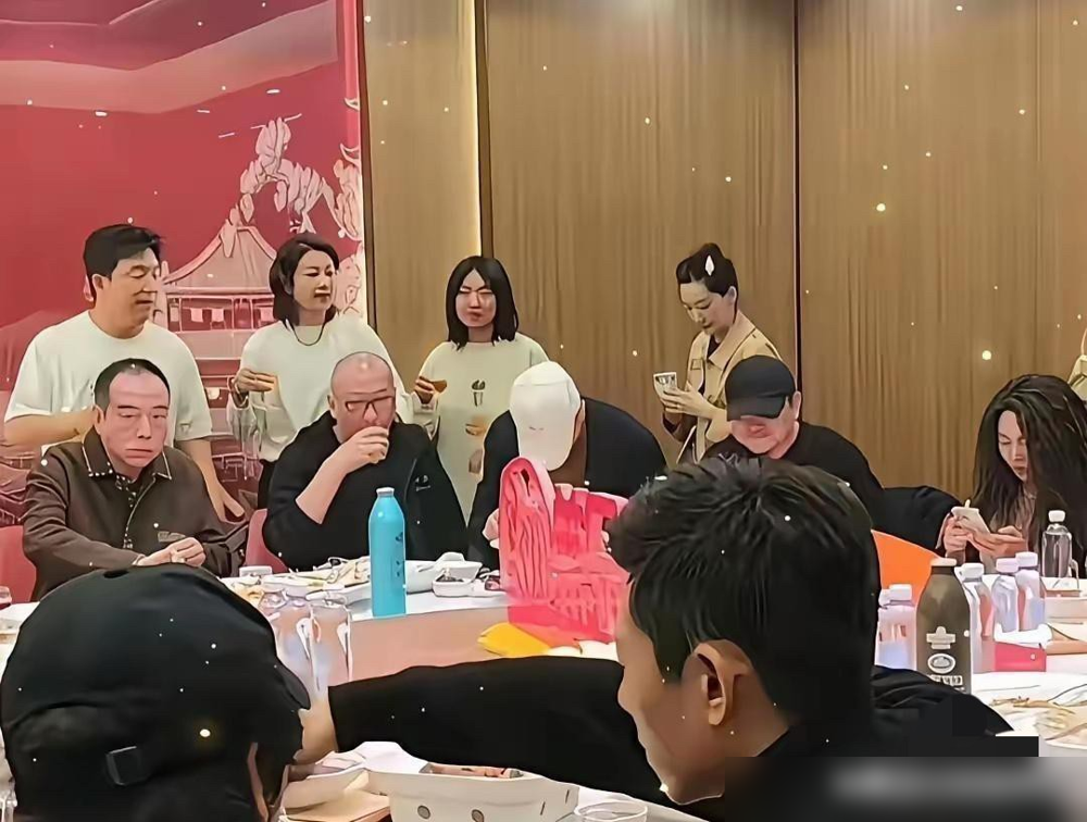 陈凯歌拎着酒瓶挨桌倒酒，旁边陈飞宇站着，手都不知道往哪放。
另一段视频里，一群年轻演员排队过来敬酒，腰弯得比桌子还低，陈飞宇就在边上，熟练地续杯、递酒。
同一个饭局，两种姿态。陈凯歌给投资人剥虾，给小编剧倒酒，满面堆笑，跟平日片场那个说一不二的大导演，判若两人。
陈红素颜在旁张罗，一家子把眼色