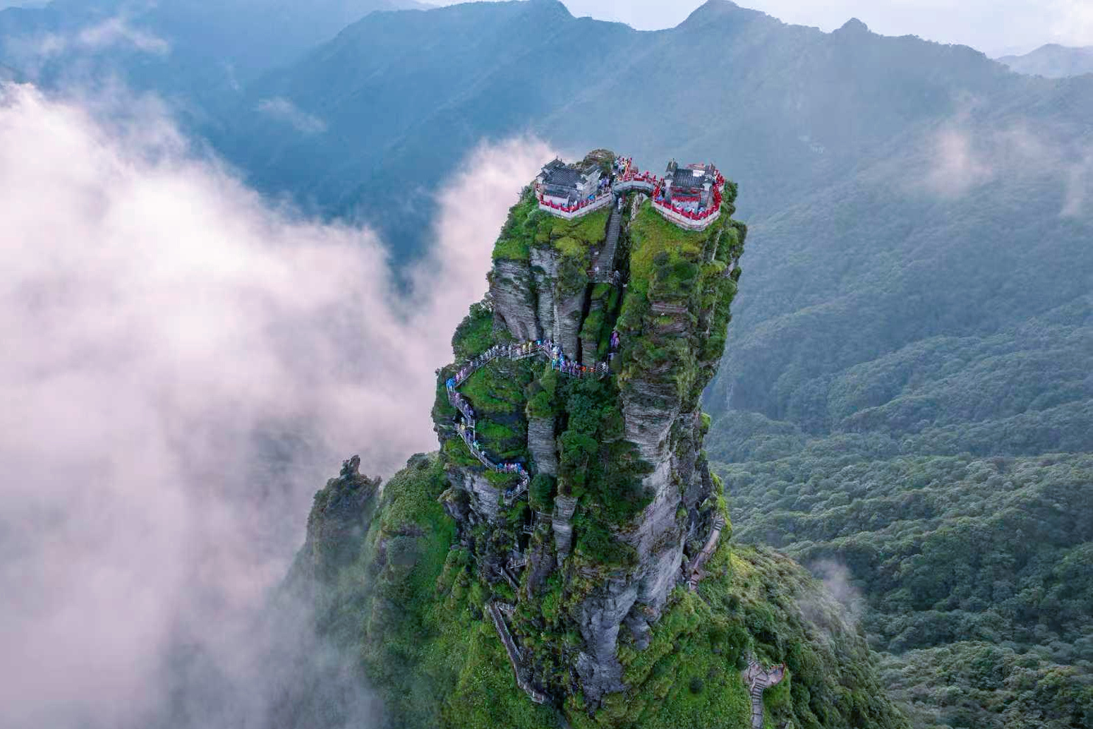 从索道开始，梵净山就一直在给我惊喜。轻便上山，缆车十几分钟穿梭云雾，从树冠之上穿过白茫茫的雾气，再钻出来就是湛蓝的天和整片云海。下了索道走几分钟到蘑菇石，再走几分钟到普渡广场扫码预约红云金顶。红云金顶那段天梯接近90度，台阶参差不齐，都不知道是怎么建成的。有时候窄到脚掌横着踩。登顶之后，站在天桥上，左右两座大殿，云就在你身边飘。那一刻你会明白：爬上去的每一步都算数。89度是坡90度是梵净山天空之城梵净山贵州梵净山日出滚滚云海似仙境