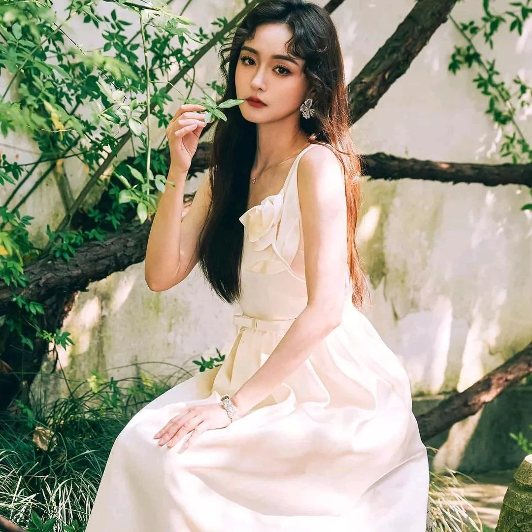 优雅女神轻抚绿叶，裙摆随风飘逸