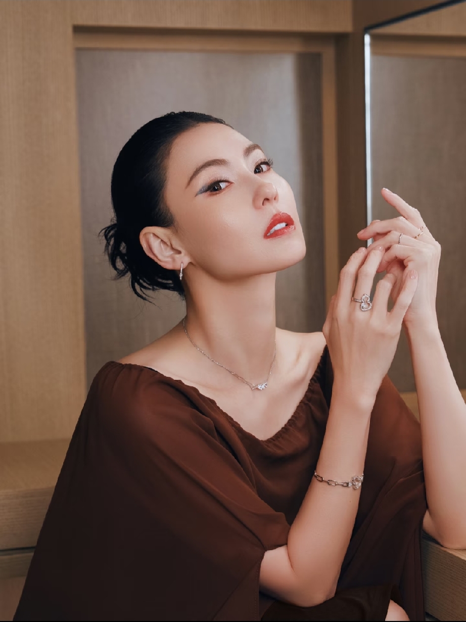 张柏芝把黑长盘发配松弛棕调薄纱，亮钻饰品衬得肩颈线条愈发优越，一抬眼还是当年惊艳时光的模样，岁月只在她身上沉淀出更致命的优雅风情与冷艳贵气。