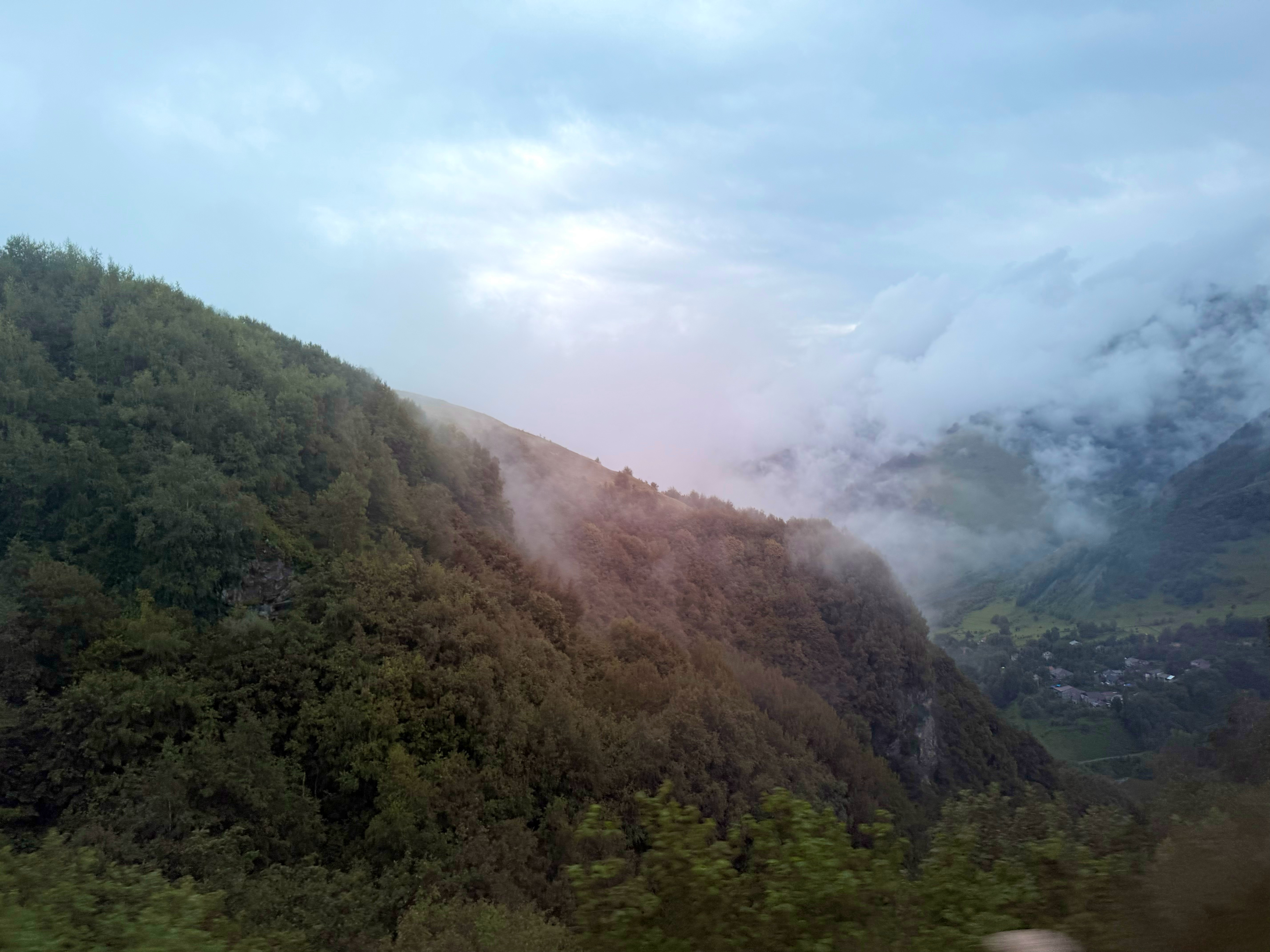 今天早上一出门就是大风大雨，哆哆嗦嗦冒雨也看不出景色好在哪里，然后山里又是多云多雾的，云几乎已经降到半山腰，天空看上去几乎是纯白色。
结果下午到了卡兹别克天气好起来了，在盘山公路上东倒西歪顶着时不时变成3G的信号打开pw发的无数张表格一边觉得好贵一边又焦虑现在不买万一真的就看不成了 ​