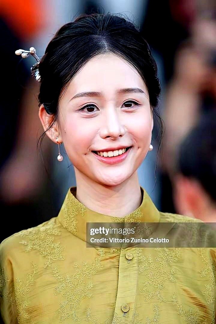 威尼斯红毯上全在拼深V透视，外国记者的长枪短炮却死死盯住了一块素布。

中国女孩王晓慧提着裙摆往前走。没露背，没挤沟，衣服布料紧贴身子。她没对着镜头凹造型，嘴角扯出一个梨涡，眼神定定地扫过去。

周围全是恨不得抢C位的人，外媒的快门声却全砸在这个连浓妆都没画的中国面孔上。

刻在骨子里的干净，才是最