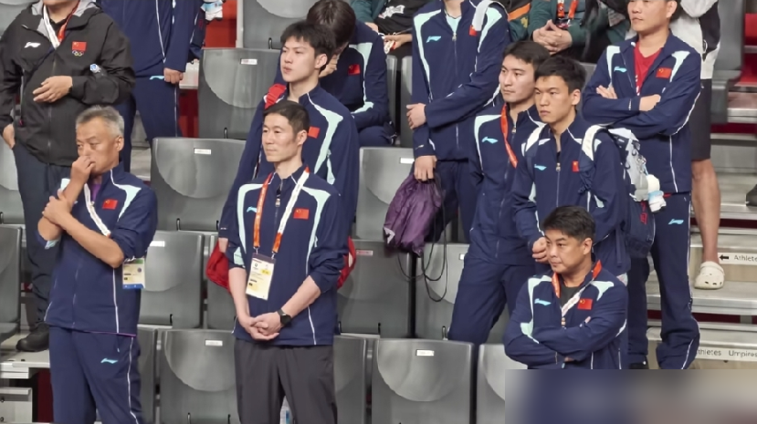 秦志戬手都抬起来了，又硬生生缩回去。
林诗栋4比0横扫王楚钦，拿下亚运男单金牌。镜头扫到看台，总教练下意识想鼓掌，一扭头，周围教练席全绷着脸，没人吭声，他那只手就悬在半空，最后尴尬地放下了。
自己人打自己人，赢了不能笑，输了不能哭，这是国乒的潜规则。可程靖淇解说时说了句大实话：王楚钦现在感受不到