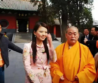 当年，李湘去少林寺采访释永信时的照片。当时的湘姐32岁，穿高跟鞋配粉色...