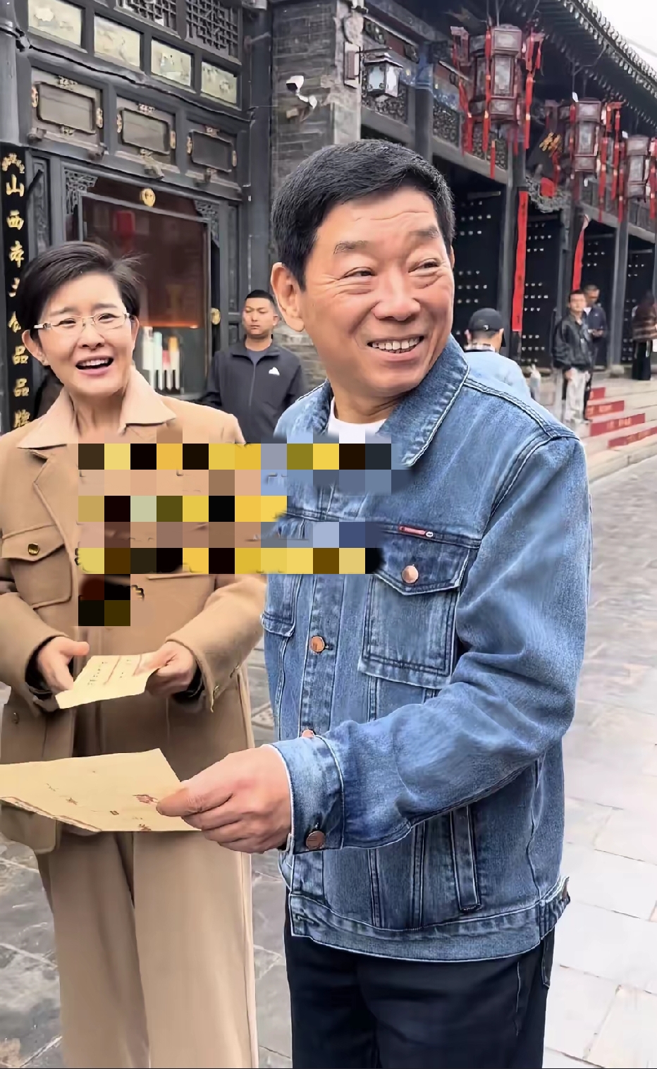 长城汽车董事长魏建军与央视主持人王宁在山西平遥古城日升昌票号门前做探访直播时的一幕。