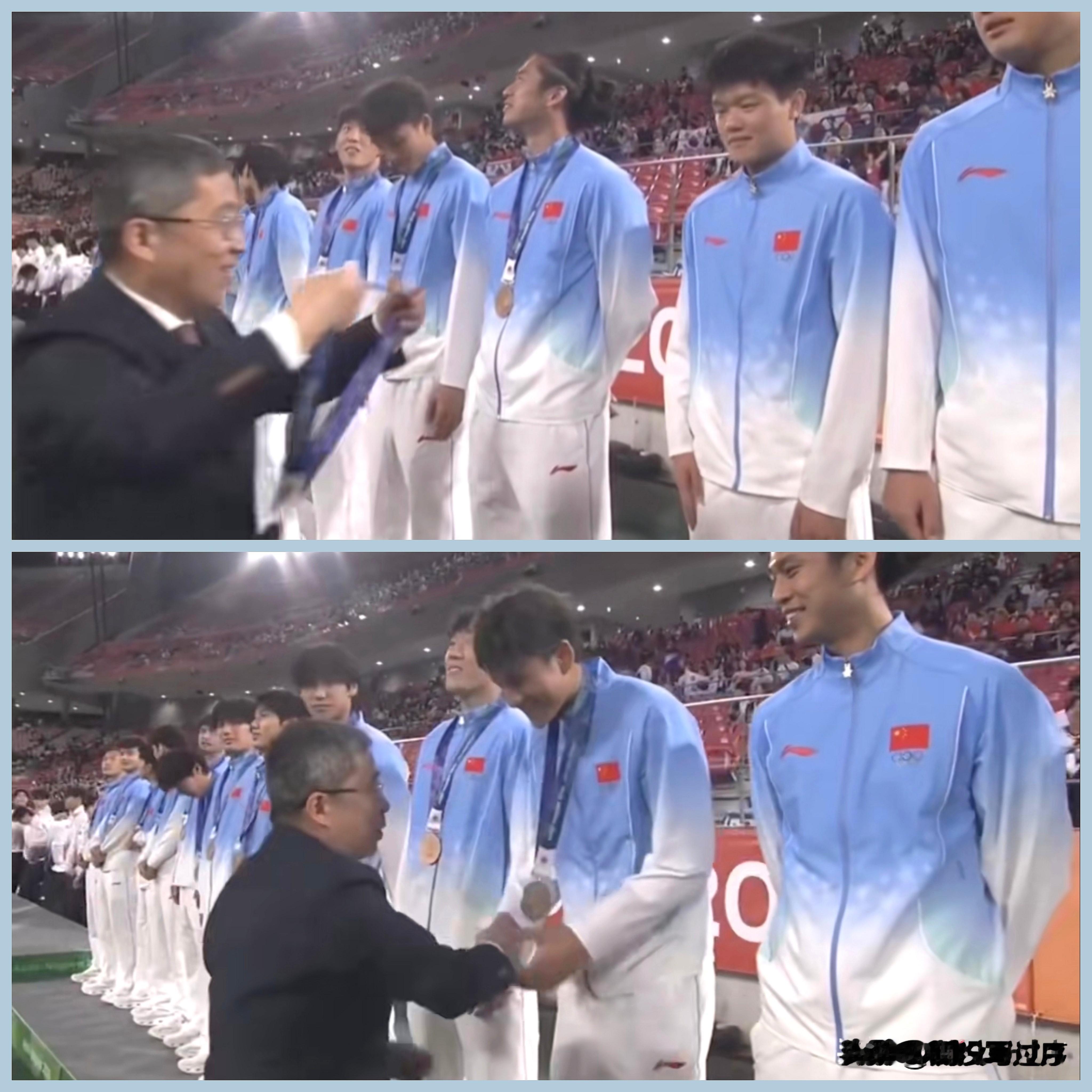 【U23国足幸福时刻：上新闻联播，堪与金牌媲美！】

昨日，铜牌🥉之战，U23国足常规时间2比2，点球4：3（总比分6：5），时隔二十八年重登领奖台，赢得如金子般之铜牌（下图①）。

该颁奖嘉宾是亚奥理事会/本次亚运会组委会之日籍代表？请问其谁？

当晚，U23国足亚运摘铜，《新闻联播》播报，足见分