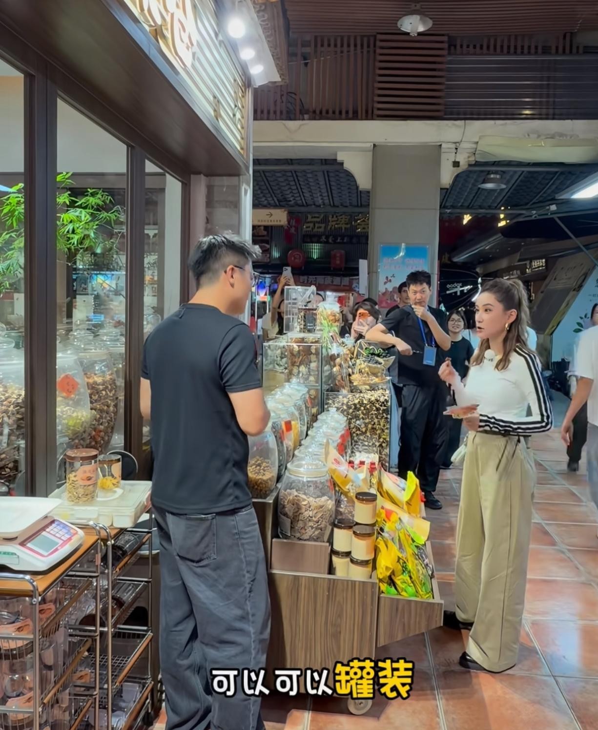 身家百亿的赌王千金跑去特产店挑陈皮，这画面怎么看都透着一股接地气的违和感。
在江门录节目的何超莲，工作间隙一头扎进了陈皮村。
站在货架前，她捧着玻璃罐一个一个端详，身边围了一圈看热闹的路人和工作人员，神情看着相当内行。
很多人以为豪门千金十指不沾阳春水，其实她对做买卖和吃喝门道一直很上心。