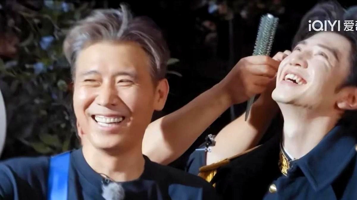 38度的高温片场，老戏骨瘫在椅子上睡死过去，一身厚重戎装的陈哲远却悄悄干了件事。

他没喊助理，自己把电风扇一点点挪到前辈李乃文面前，还掏出手机拍下这真实的一幕。

就在几个小时前，李乃文刚把陈哲远的台词全盘过了一遍。哪句拗口，哪句得调顺序，掰开了揉碎了讲。陈哲远连连点头，结果一开口，舌头打结全记混