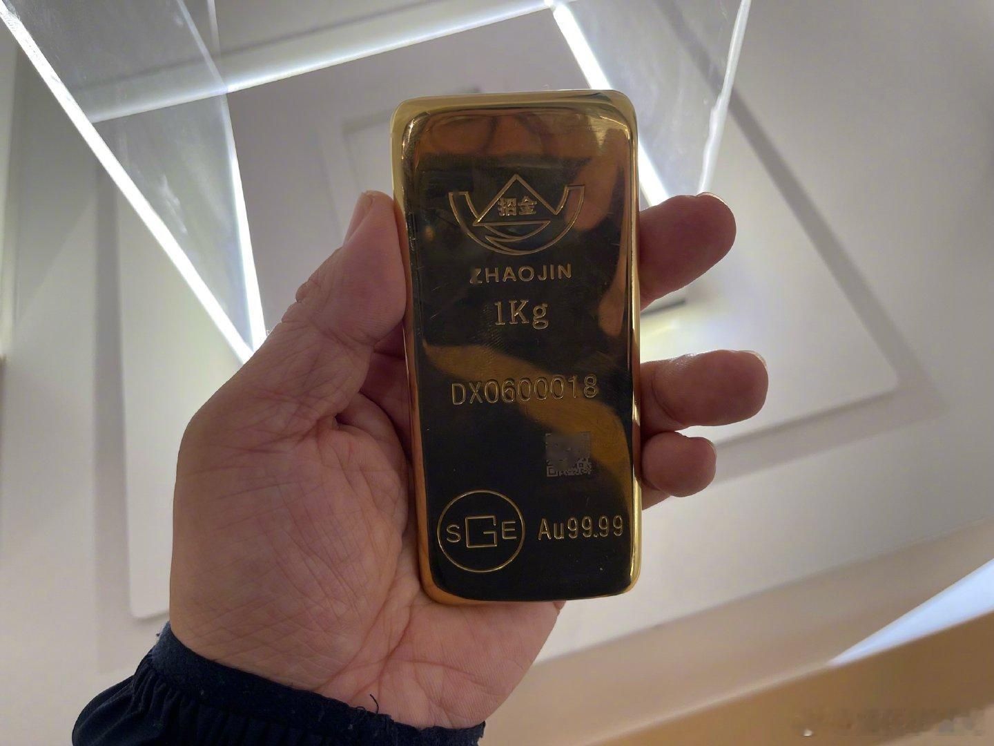 #探访中国金都招远#在招金金银精炼有限公司二楼展示馆，亲手试了试了这块1KG的金砖。那重量与光泽，不仅是视觉与触觉的双重体验，更是招远黄金产业硬核实力的具象化缩影。
      这块金砖的背后，是招远绵延两千多年的黄金开采史，更是如今千亿级全产业链的生动写照。从罗山深处的矿石开采、智能冶炼， ​
