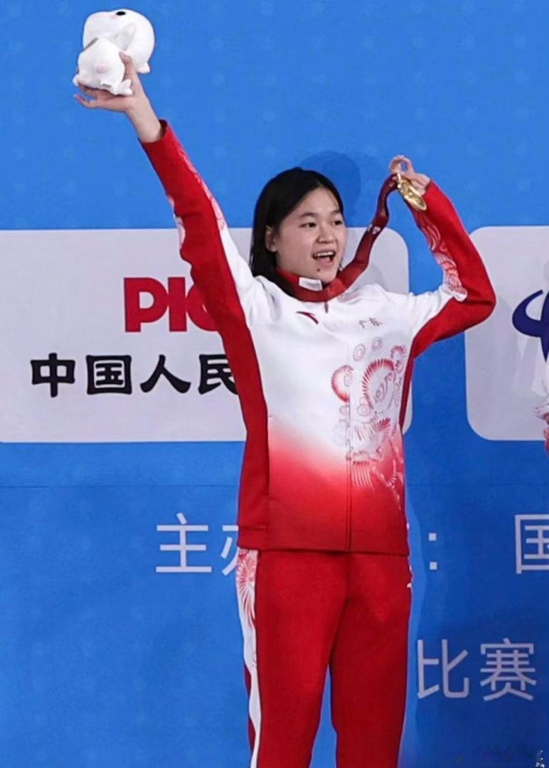 现场的全红婵头戴棒球帽，一身休闲穿搭，披肩长发，尽显青春少女感，安静坐...