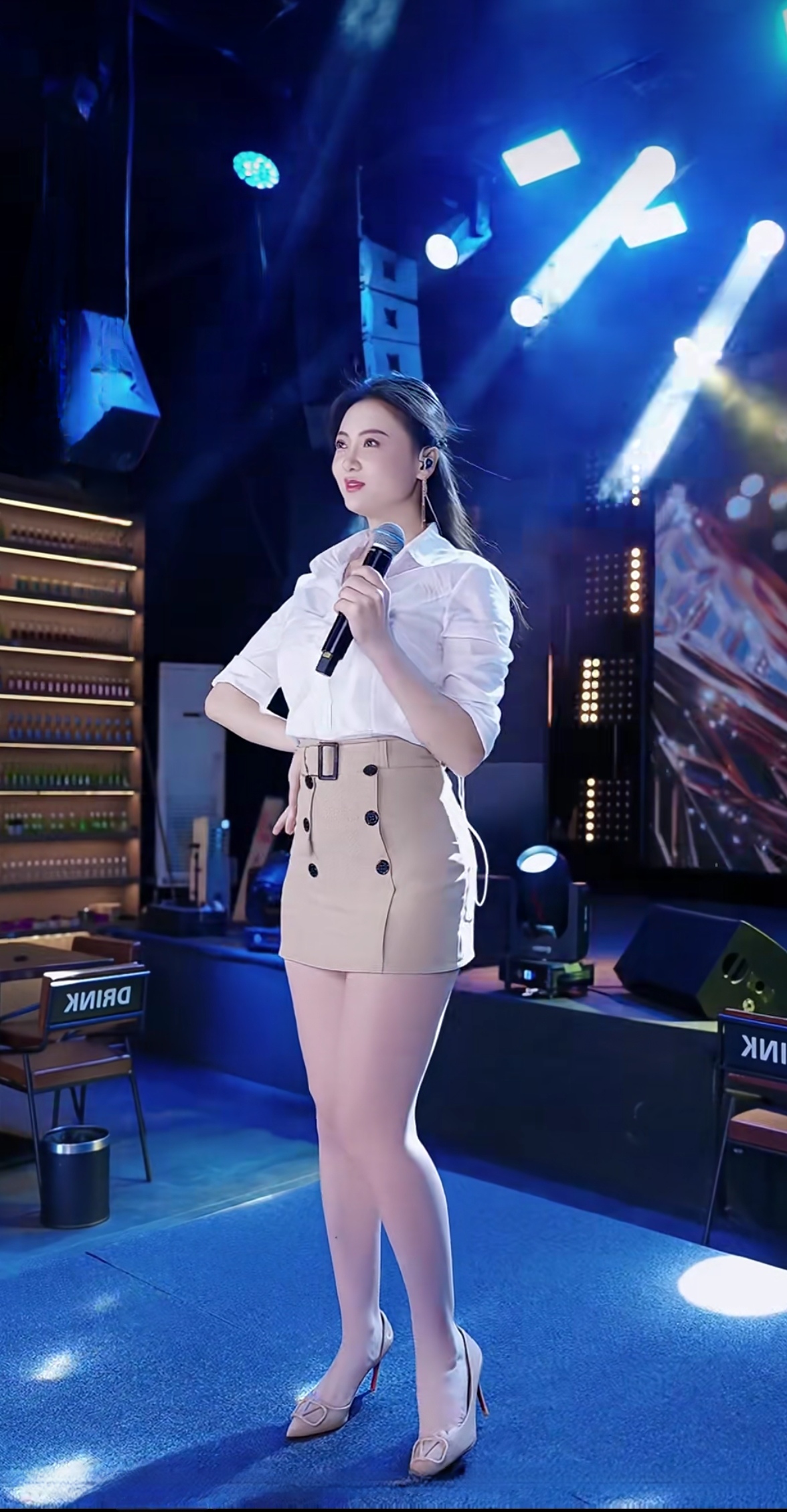 舞台上的优雅女神，自信地握着麦克风，散发着迷人的魅力！