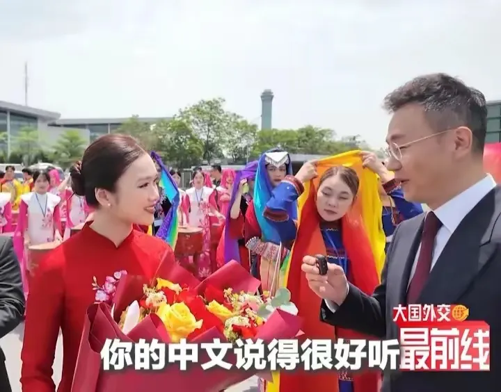 踏入越南的机场，一抹明艳的中国红瞬间抓住了众人的目光。那是一位越南小姐...