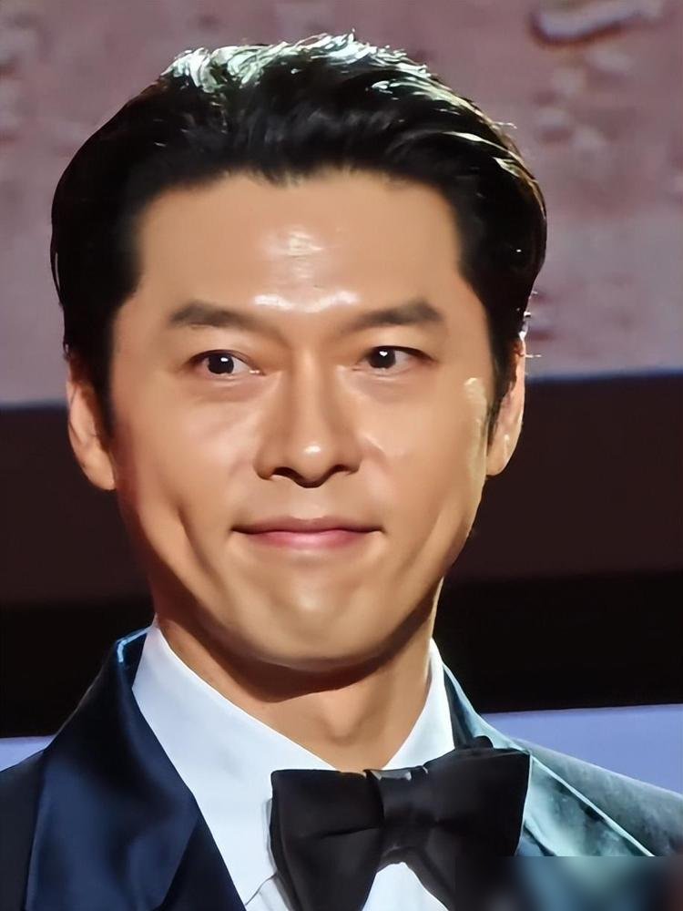 玄彬这张脸，直接把韩国医美界干沉默了。
釜山红毯生图一出来，全网都在截图他的发腮和皱纹。镜头怼到脸上，松弛、疲态、法令纹，一样没跑。跟那些打了针绷得像剥壳鸡蛋的男明星站一块，他像个走错片场的普通人。
可你再看他今年干的事。为了《韩国制造》增重14公斤，演个疯批权谋男，百想视帝直接揣兜里。第二季刚