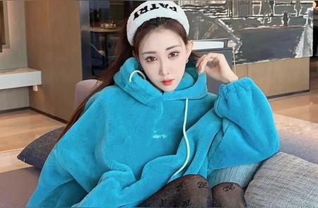 蓝衣佳人坐沙发，长发飘逸似仙姿。