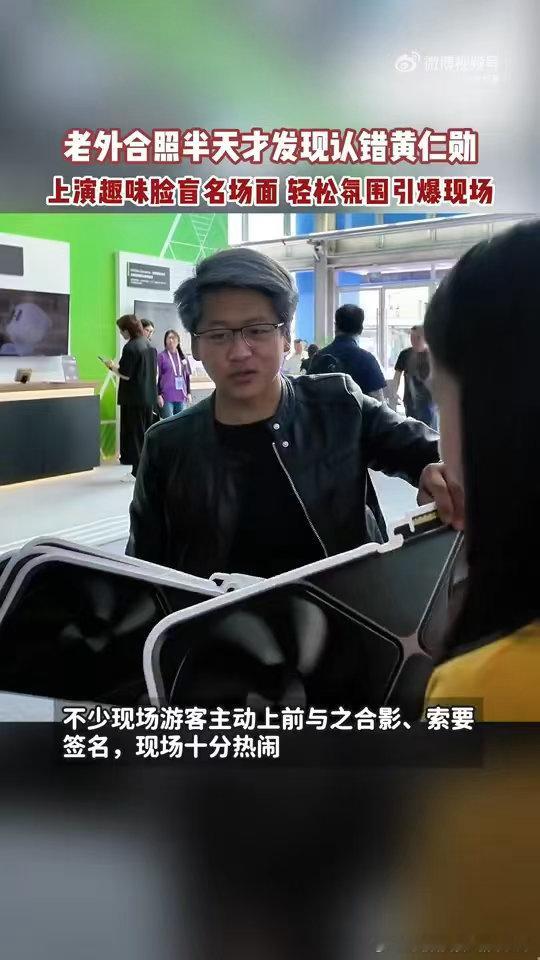 #老外合照半天才发现认错黄仁勋#外滩大会现场的趣味小插曲！博主黄银勋一身黑皮衣，带着打印显卡道具和路人互动，外国游客远远误认，走近才发现并不是黄仁勋本人。 ​