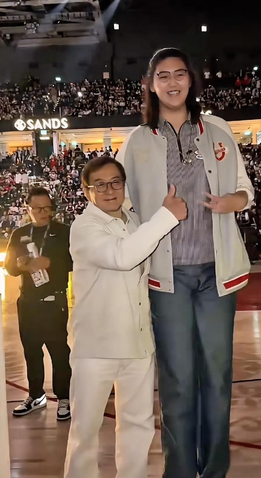 成龙大哥这辈子走南闯北什么大场面没见过，偏偏在女篮姑娘张子宇面前，硬生生被衬托成了“手办大小”。
两个人站一块儿的画面实在太有喜感。
张子宇净身高226公分，跟姚明几乎打平，而成龙是173公分。整整53厘米的落差，成龙往那一站，脑袋顶甚至够不着小姑娘的肩膀，仰头说话都显得费劲。
换作平时爱立人