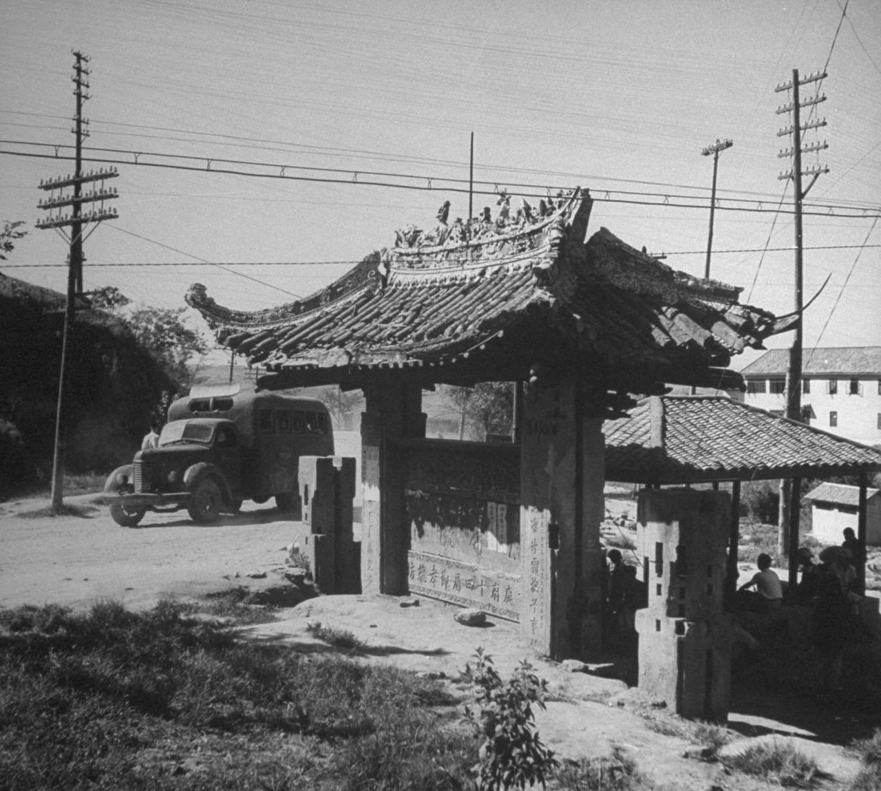 1945年11月，重庆。 一个牌坊，写着“广府十四属节孝牌坊”。 何为...