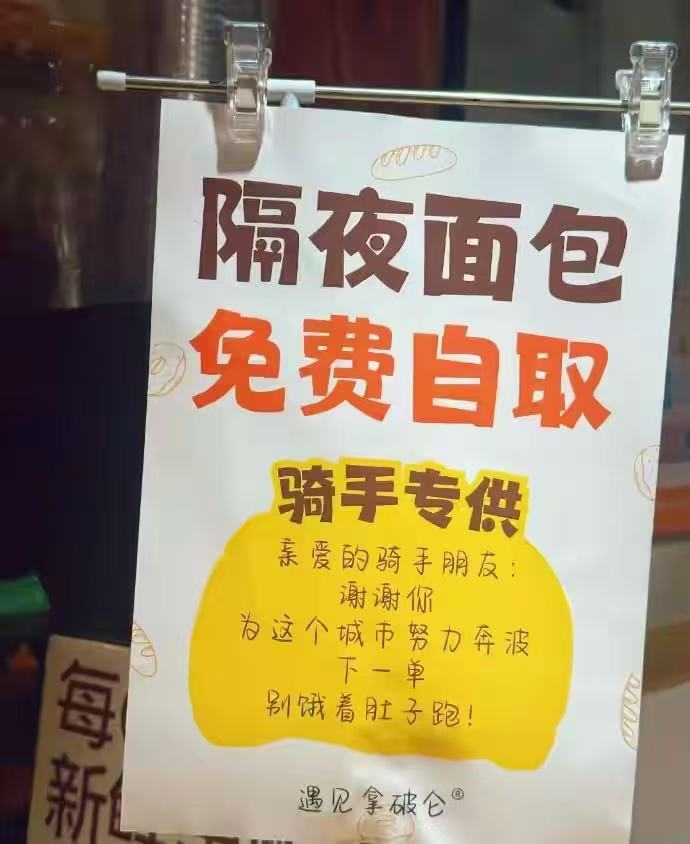 熙南里大板巷口那家面包店，靠墙的角落里贴了张纸。彩色的，不大，字是手写的。
“隔夜面包，免费自取&34;后面又加了四个字：骑手专供。
底下还有一行小字，是写给骑手的：谢谢你为这个城市努力奔波，下一单别饿着肚子跑。
这家店叫&