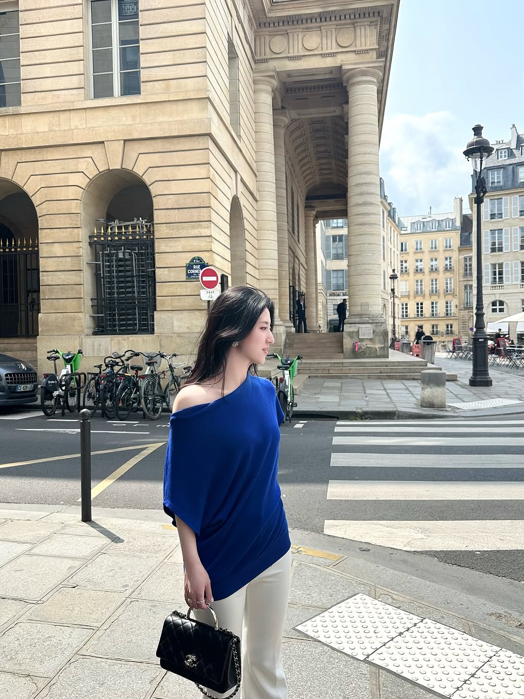 在巴黎街头，蓝衣女子漫步，优雅迷人。