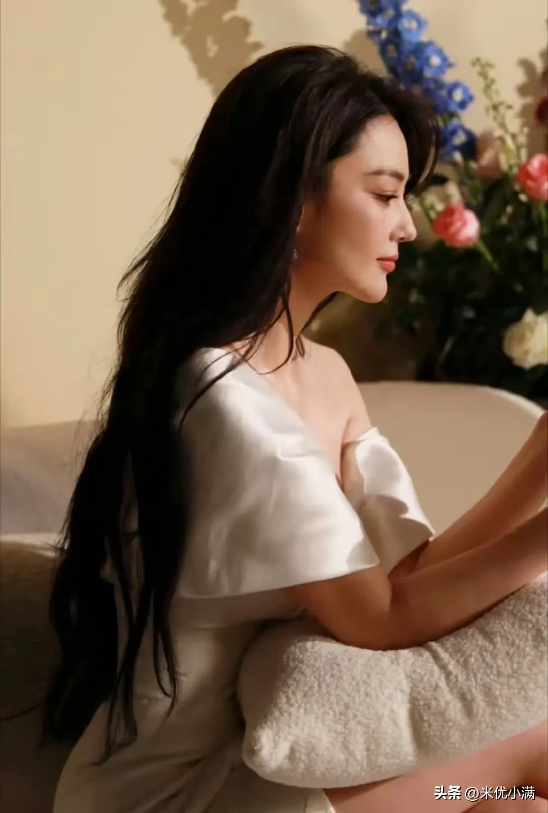 张馨予缎面白裙花海写真刷屏网络。这件一字肩礼裙像凝固的牛乳，顺滑面料勾勒出饱满线条，乌黑长卷发自然垂落，各色鲜花环绕身旁，暖调光线铺洒画面，静坐回眸，镜前转身的动作舒展大方。不少圈内熟人私下唠，大伙都夸她褪去往日凌厉气场，时尚博主紧跟着拆解这套氛围感拍摄技巧，很多网友搜寻同款缎面礼服，影楼也计划上线
