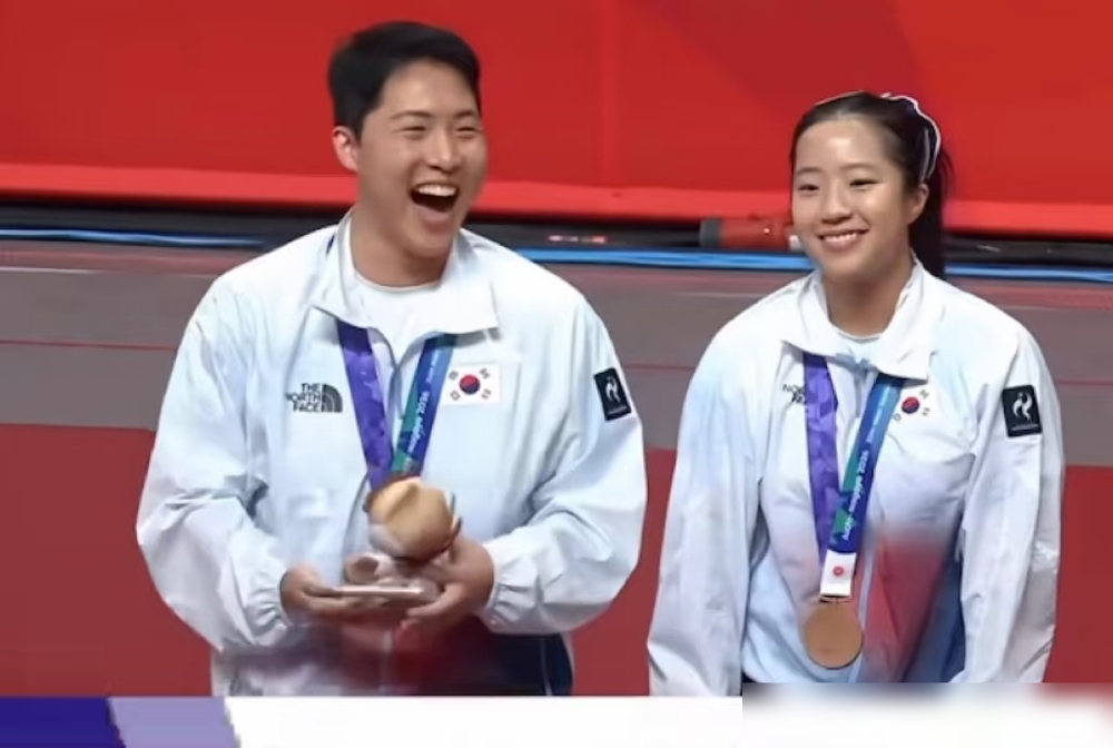拿了块铜牌，这韩国男人笑得比拿金牌还狂。
乒乓球混双赛场，国乒组合拿下冠军。
但领奖台上最抢戏的，却是举着手机疯狂自拍的韩国铜牌得主林仲勋。
这画面让人秒回巴黎奥运，当时27岁的他拼下一枚混双铜牌，距离他强制入伍，只剩最后20天。
赢下比赛那一刻，他直接冲观众席敬了个标准军礼，把赛场变成了提