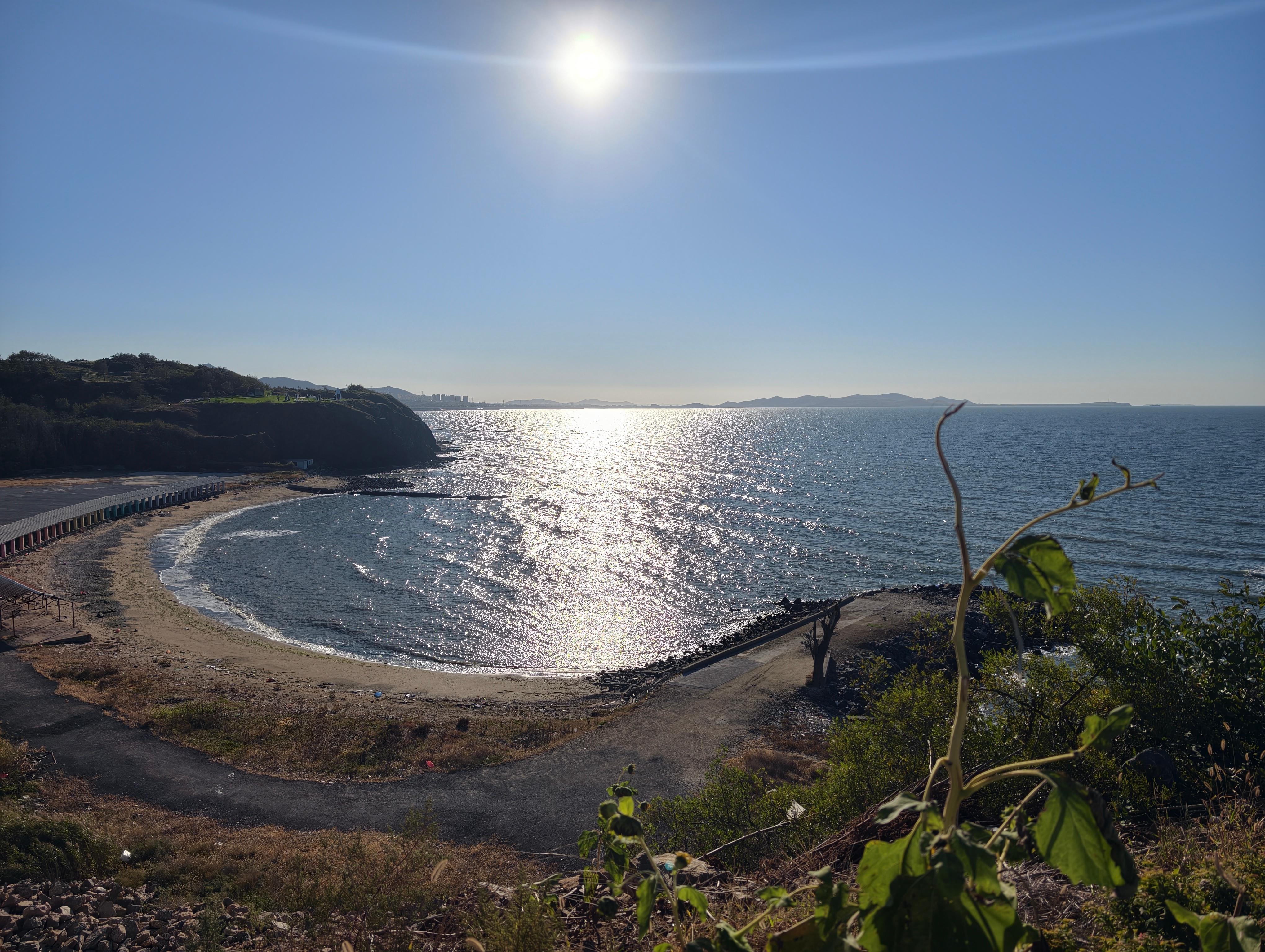 泊霞湾公园：渤海西岸，藏着大连的落日童话 盛世华章悦享大连东北超燃ai看大连万千气象看辽宁 在大连甘井子羊圈子村的海岸线上，泊霞湾公园静静依偎渤海湾，凭借斑斓的海岸风光，成为西海岸独具一格的滨海休闲空间。这里没有闹市海滩的喧嚣，山海开阔，色彩烂漫，把落日、灯塔与彩虹步道揉成独属于大连的浪漫图景。3.5公里彩虹路沿着海岸蜿蜒铺开，七彩路面如同落在大地的调色盘，一路通向崖边。海岸高地，红白相间的灯塔静静伫立，是整片公园的视觉焦点。站在灯塔平台远眺，海面辽阔，天气晴好时，远处群岛轮廓清晰可见，海蚀崖与层层海浪相映，尽显渤海海岸原始的山海质感。浪花台、鲸鱼雕塑错落分布在园区之中，一步一景，随手定格都是治愈画面。这里最动人的时刻，当属黄昏。夕阳缓缓沉入海面，漫天霞光铺洒在海面，整片大海晕染成温暖的橘色。落日的余晖给灯塔镀上金边，海风漫过崖畔，游人静静等候暮色降临，沉浸式感受落日坠海的震撼。四季风光各有韵味，夏日吹海风看晚霞，冬日可观赏壮阔海冰，不同时节，都能邂逅不一样的海岸景致。这片滨海公园...