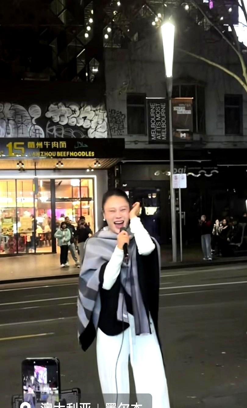 墨尔本街头，一个驻唱女孩正唱着歌，人群里突然走出来一个人，直接凑向麦克风。

走出来的正是袁娅维。女孩当时刚好在唱她的歌。

没带伴奏，她直接就清唱上了。一边唱，还一边侧过身，跟女孩比划着怎么调音，怎么找发音位置。

路人都停下脚步围了一大圈，跟着打拍子。这哪是街头偶遇，简直是手把手上了堂声乐课。