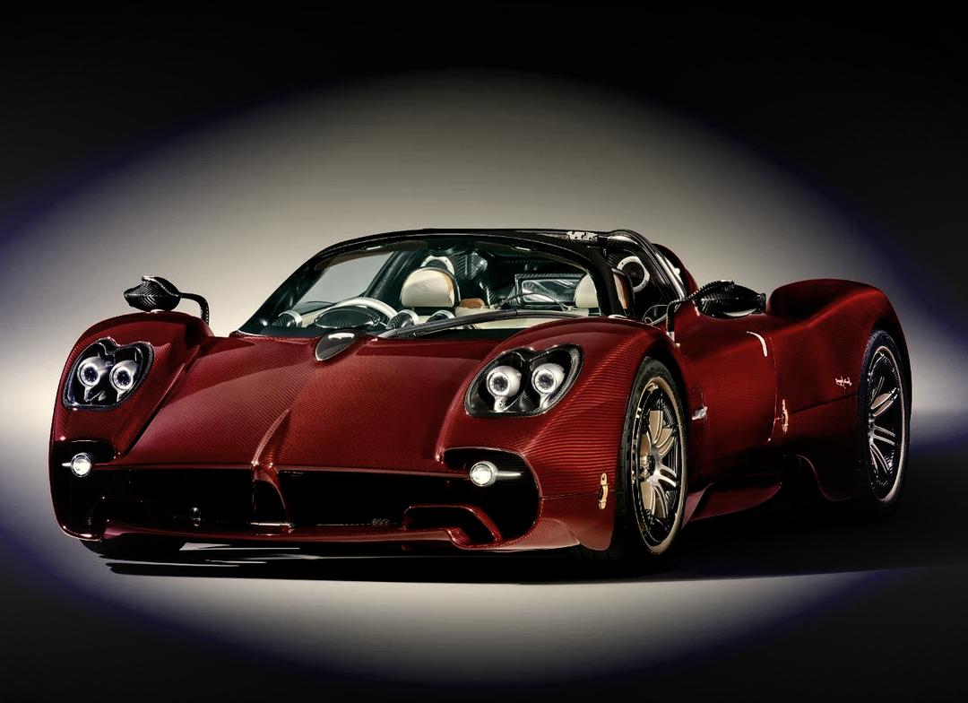上周在超跑聚会上蹲到了帕加尼Huayra Roadster BC的实拍图，至今翻相册还会反复看。
整车用了大量裸露的碳纤维纹理，连车壳缝隙里都透着手工打磨的细腻感，车尾那四出圆形排气直接怼在扩散器上方，旁边堆叠的空气动力学鳍片数了下有12片，风一吹的时候尾翼还能自动微调角度。最绝的是驾驶舱里全是裸露