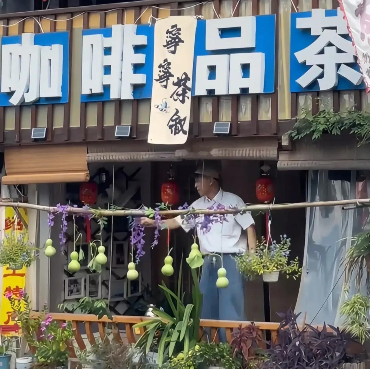 竟然出了个盗版“葫芦娃爷爷”，
而且他就在正版葫芦娃爷爷的隔壁，
是一家咖啡店，这老板一看就是
有着精明头脑，
又会做生意的人物。

就在葫芦娃爷爷把七个葫芦剪掉后，
盗版葫芦娃爷爷
脑子飞快想到这个接流量的方法，
搞了几个葫芦挂在自家咖啡店门口，
效仿起正版葫芦娃爷爷。

不知道他能否接住这波流量