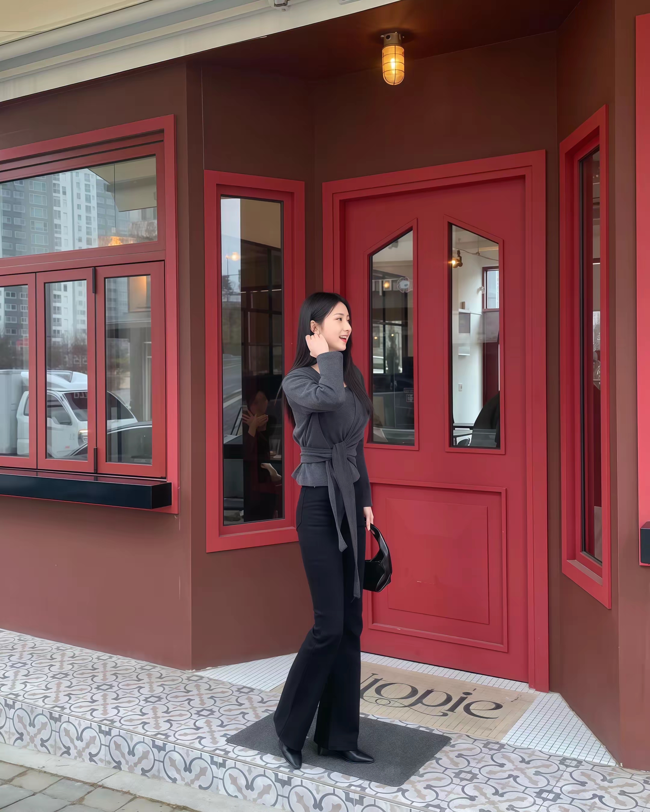 优雅黑衣女子，站在红色门前的时尚瞬间，气质高雅端庄靓丽