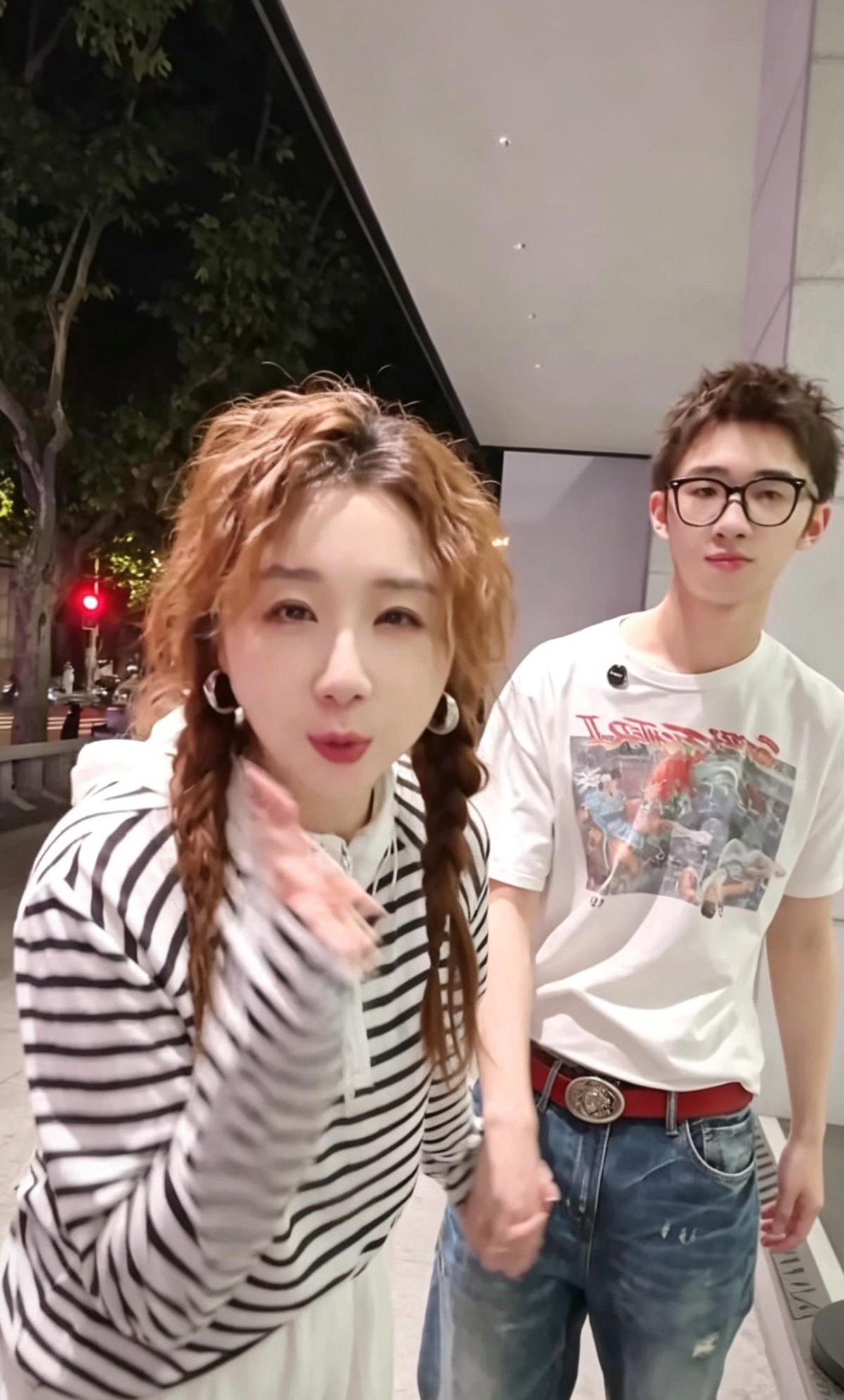 傅首尔瘦了快四十斤之后陪儿子逛街，画风彻底反过来了。视频里她扎着双麻花辫，黑白条纹衫配白裤子，整个人轻得像是换了壳。十七岁的多乐已经快一米八，站在她旁边挑衣服，认真给她推荐年轻人的街头穿搭。傅首尔没有摆出家长的架子说“这什么乱七八糟的”，儿子递过来一件领口设计夸张的外套，她真就套上了，两个人对着镜子