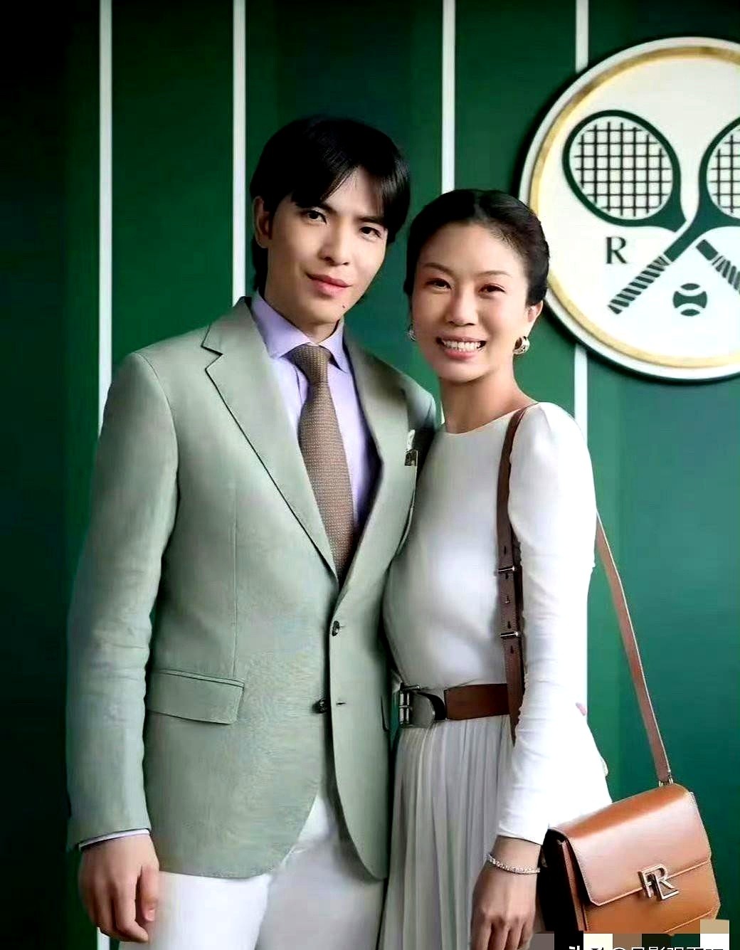 37岁萧敬腾和54岁老婆同框，硬是把温网看台变成了秀恩爱现场。

温网那面深绿竖条纹墙前，两人紧紧贴着。萧敬腾一身浅绿西装配白裤子，清爽利落。

大他17岁的林有慧，一条纯白长袖连衣裙，腰间系根棕色皮带，单肩包一挎，干练又得体。两人对着镜头一笑，那种经年累月的默契根本装不出来。

感情好不好，看下意