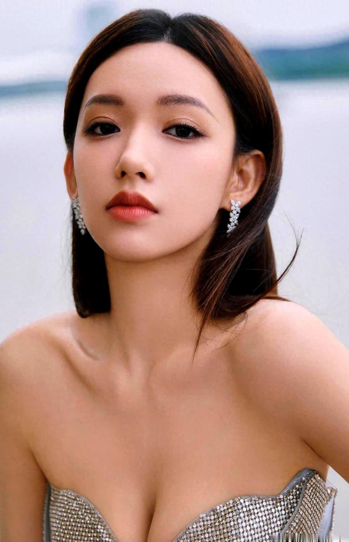 说句实话，这套银色满钻抹胸裙，换个人穿可能就是灾难。

程潇这次亮相，直接把高调穿在了身上。裙身层层叠叠铺满水钻，灯光一打，整个人都在闪。她没搞复杂的造型，就是最简单的柔顺中分长发，配上小巧的碎钻耳饰，硬生生压住了这条喧宾夺主的裙子。

抹胸设计一点没藏着掖着，优越的肩颈线条完全暴露在外。最绝的是这